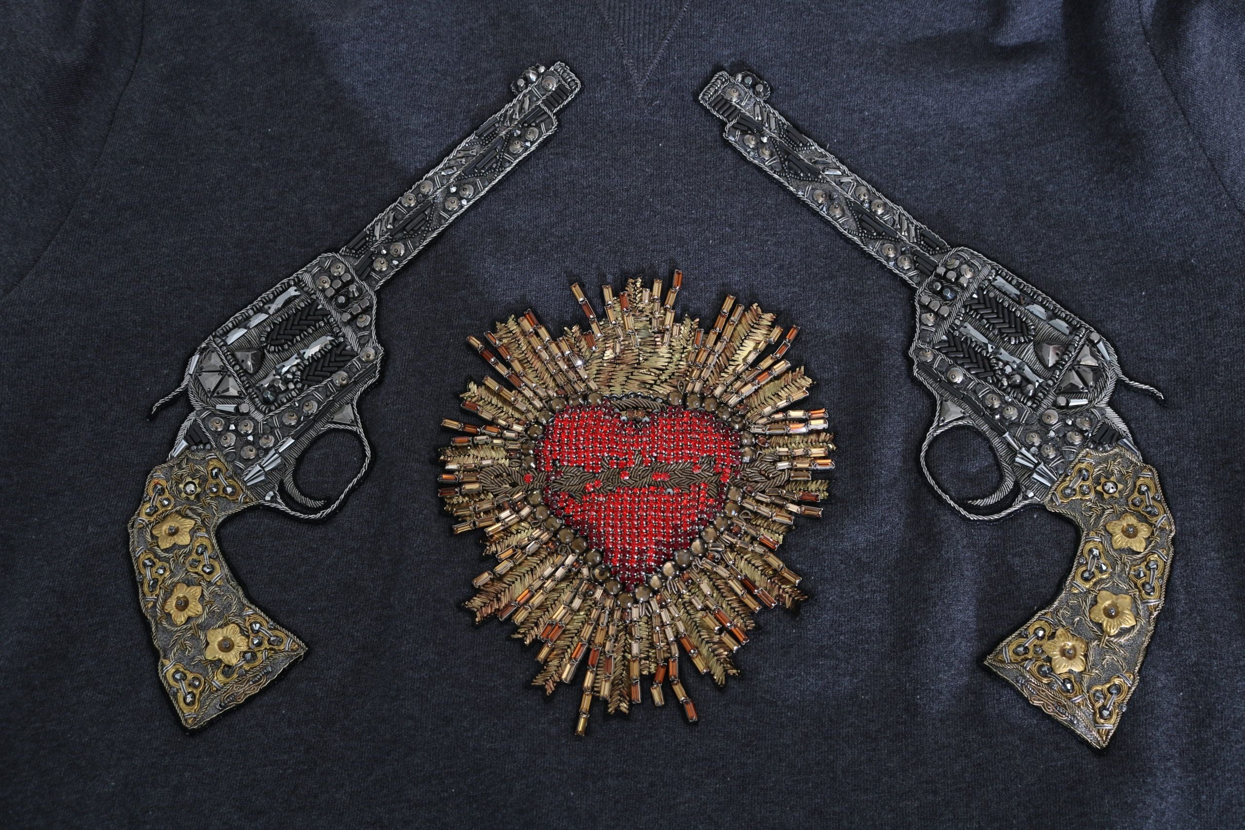 Grijze capuchontrui met rood kristalhartpistool