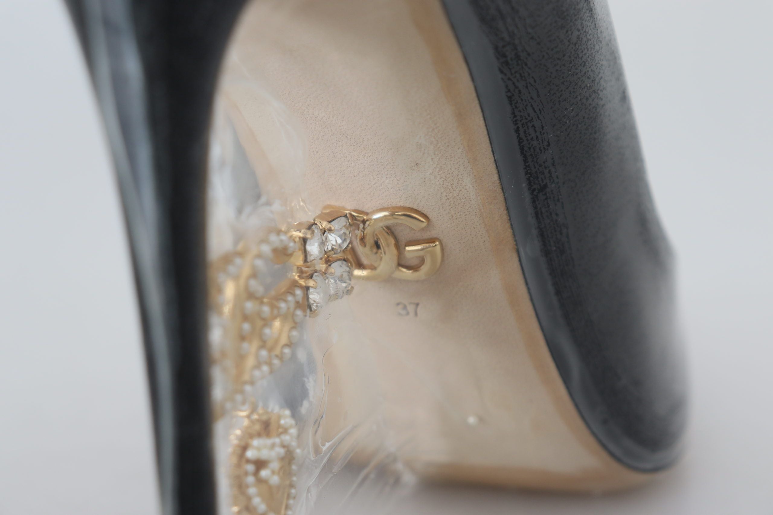 Zwarte leren pumps met hak en plastic verpakking