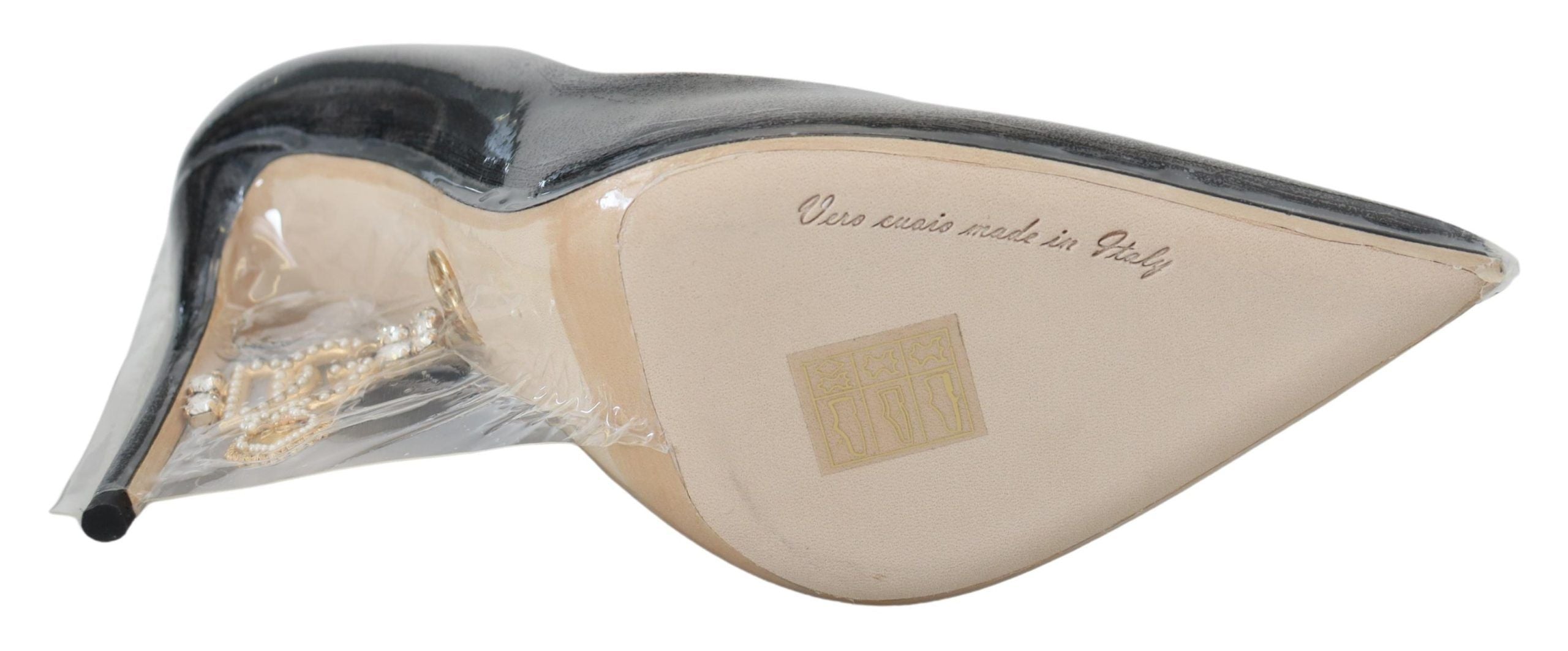 Zwarte leren pumps met hak en plastic verpakking