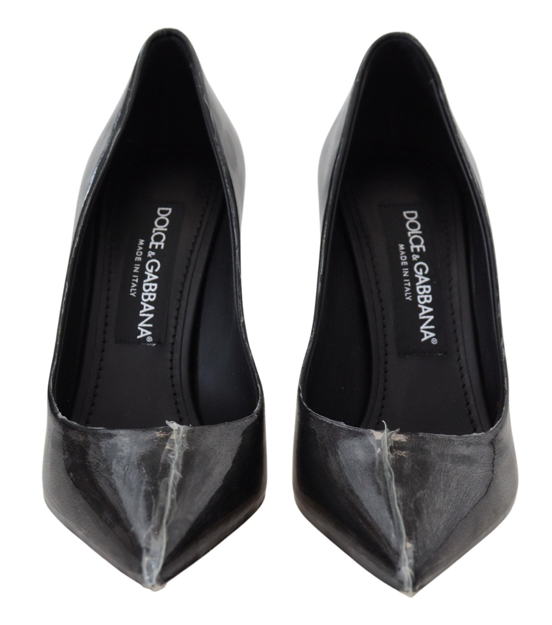 Zwarte leren pumps met hak en plastic verpakking