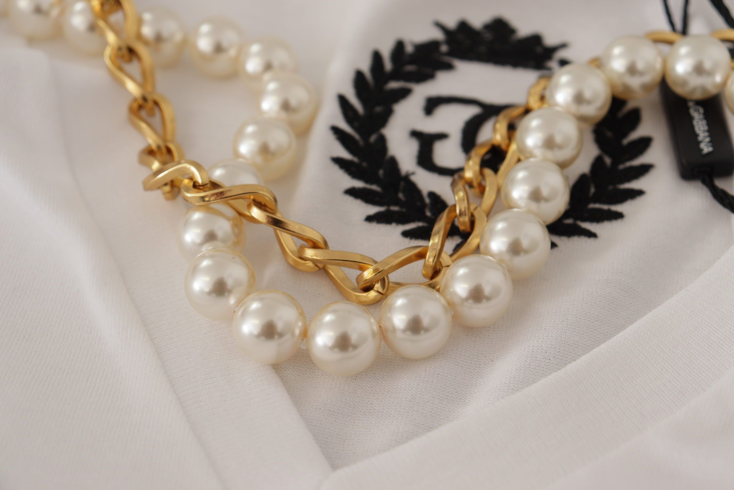 Witte T-shirttop met ketting en versierde halslijn