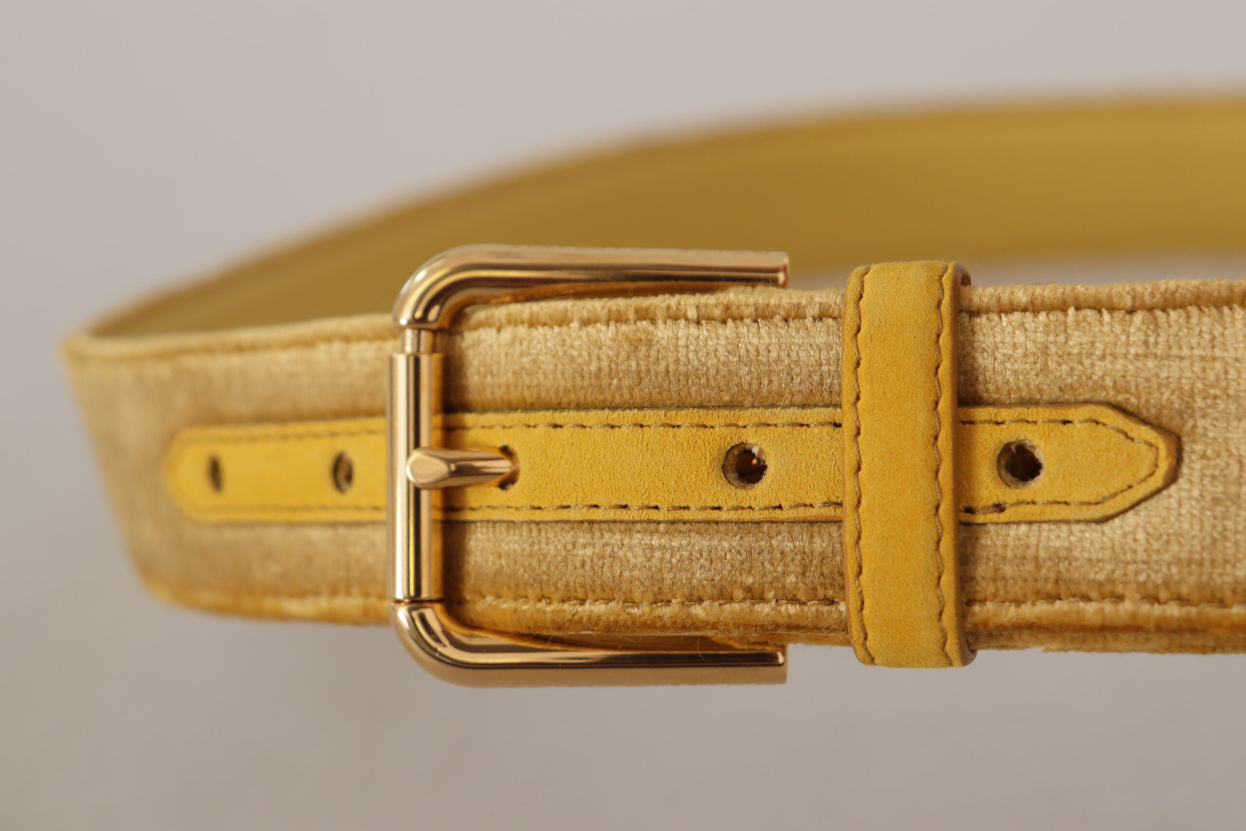 Gele fluwelen riem met gouden metalen logo en gegraveerde gesp