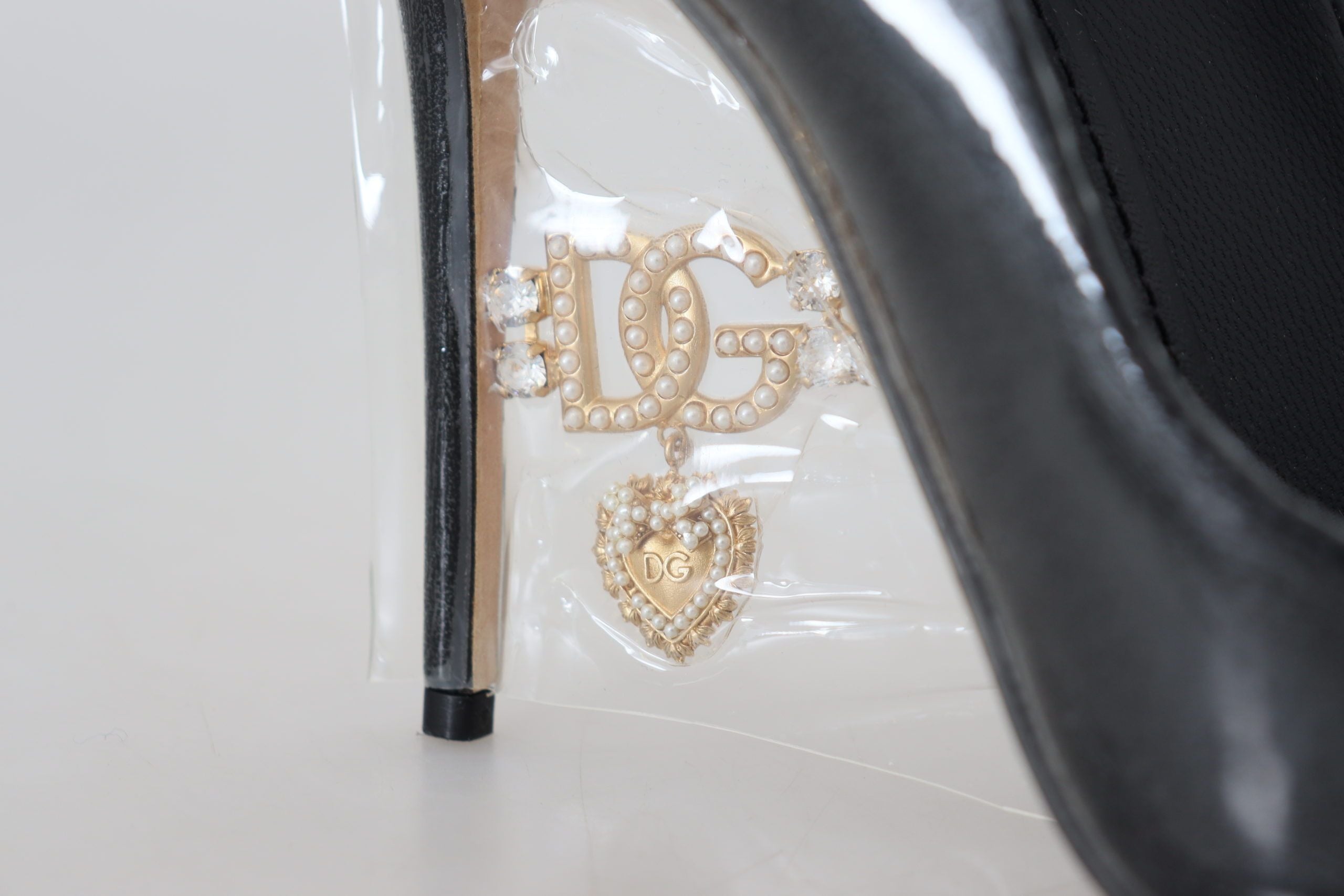 Zwarte leren pumps met hak en plastic verpakking