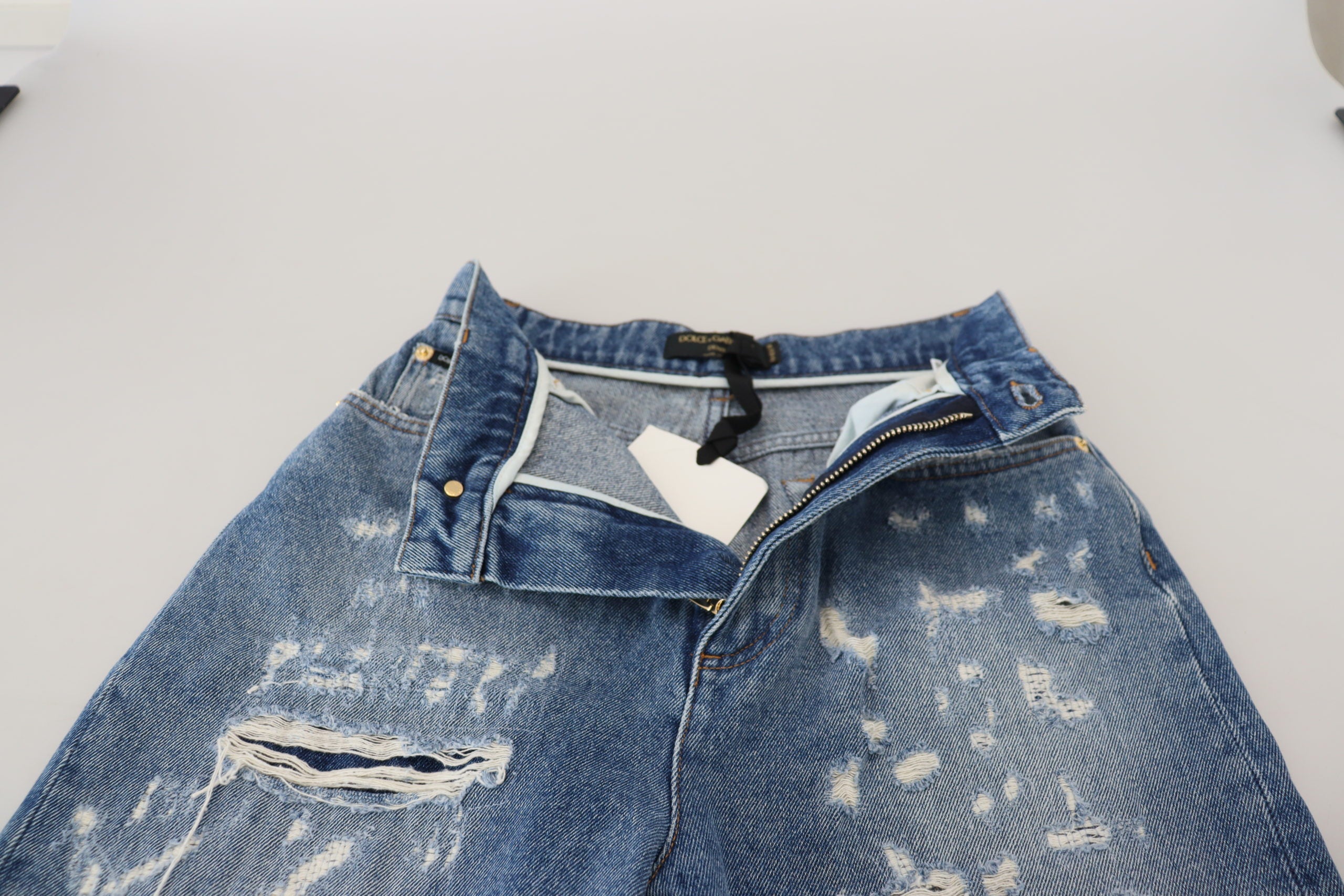 Blauwe gewassen katoenen gescheurde denim jeans