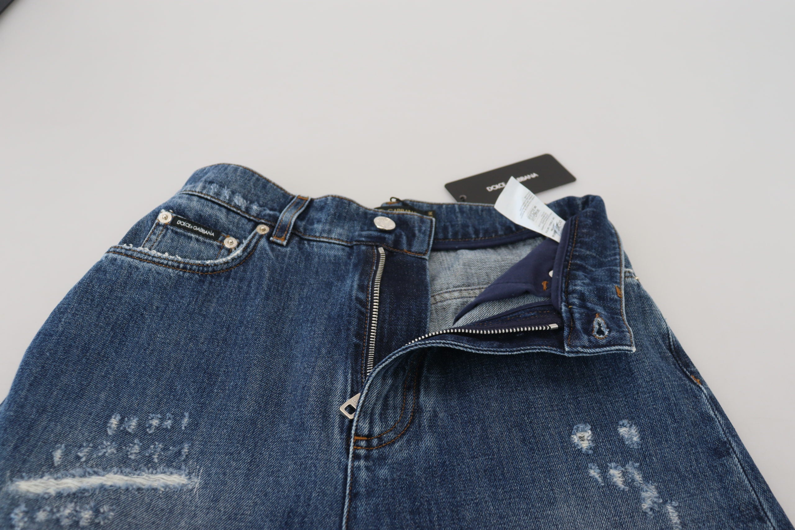 Blauwe gewassen katoenen gescheurde denim jeans