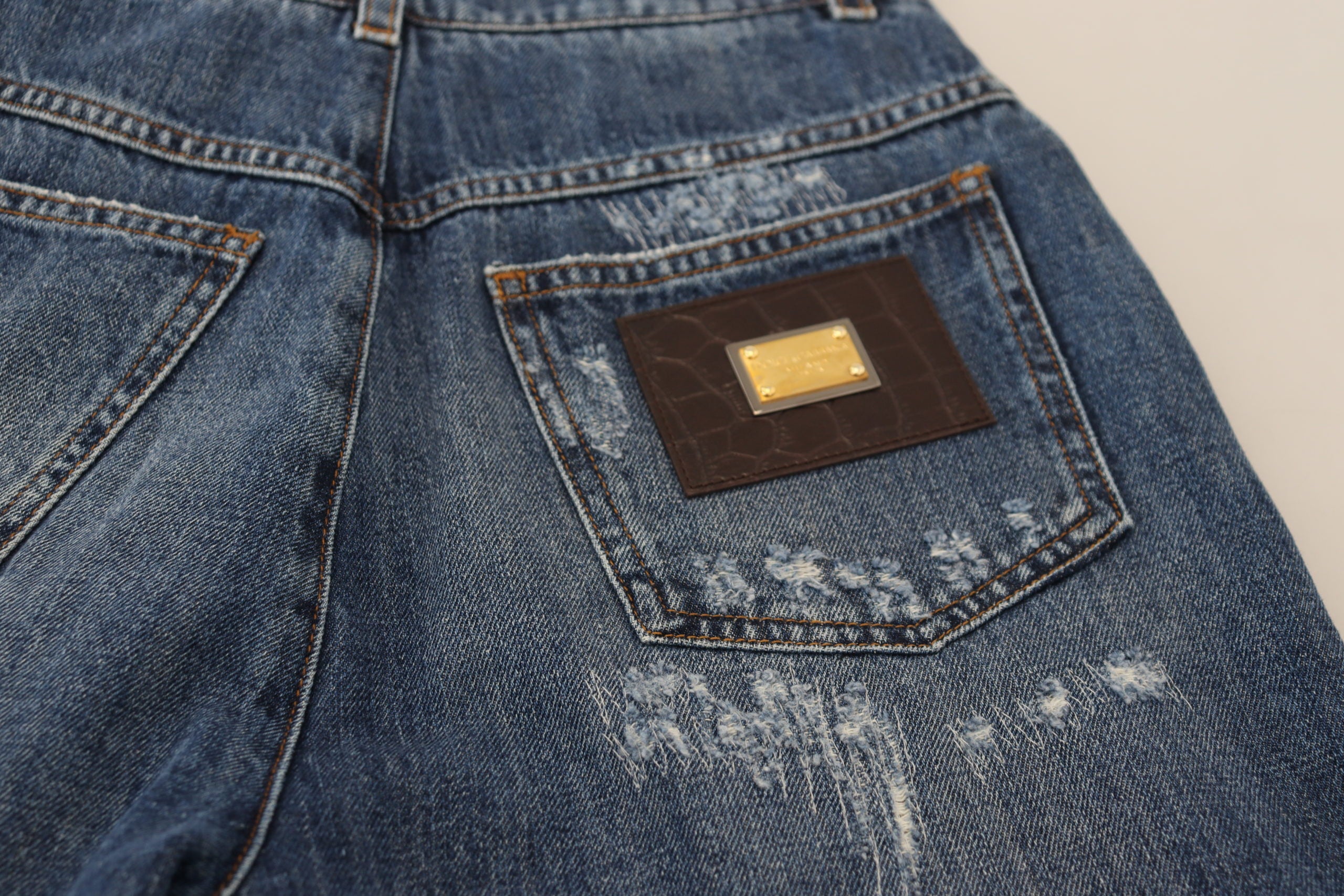 Blauwe gewassen katoenen gescheurde denim jeans